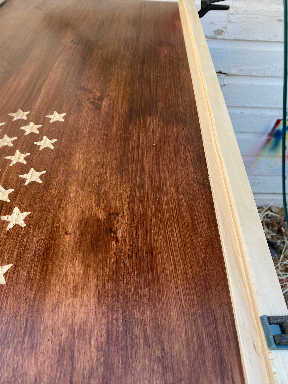 Wooden surface with engraved star patterns on a wooden shelf.