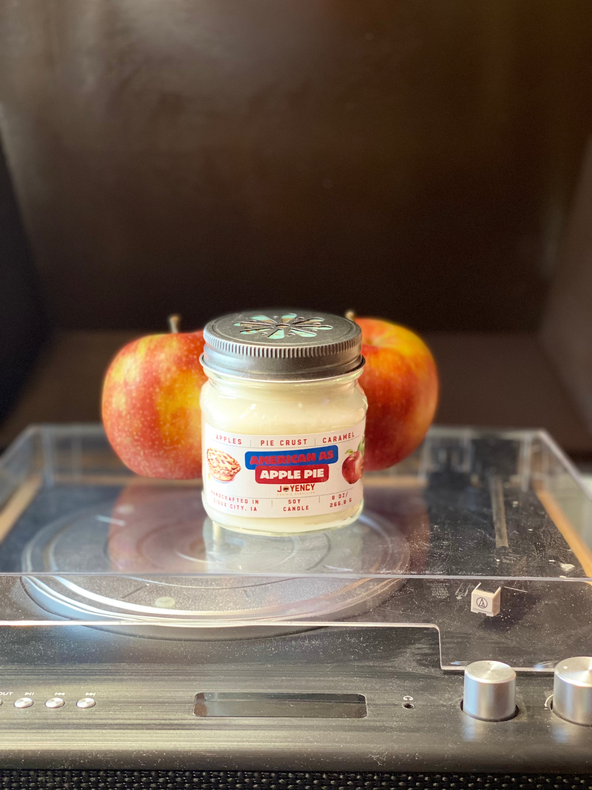 Jar of 'Apple Pie' jelly with two apples on a metallic surface