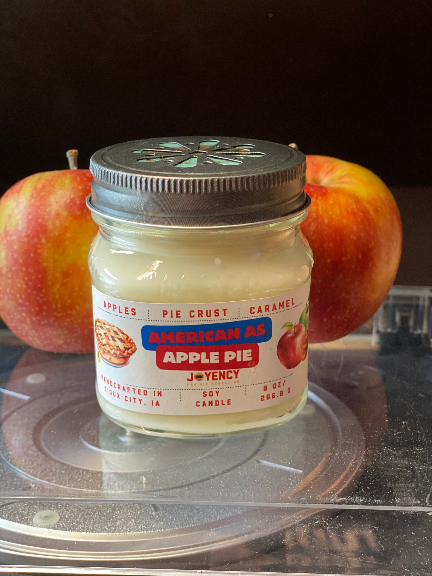 Jar of 'American As Apple Pie' candle with apples in the background