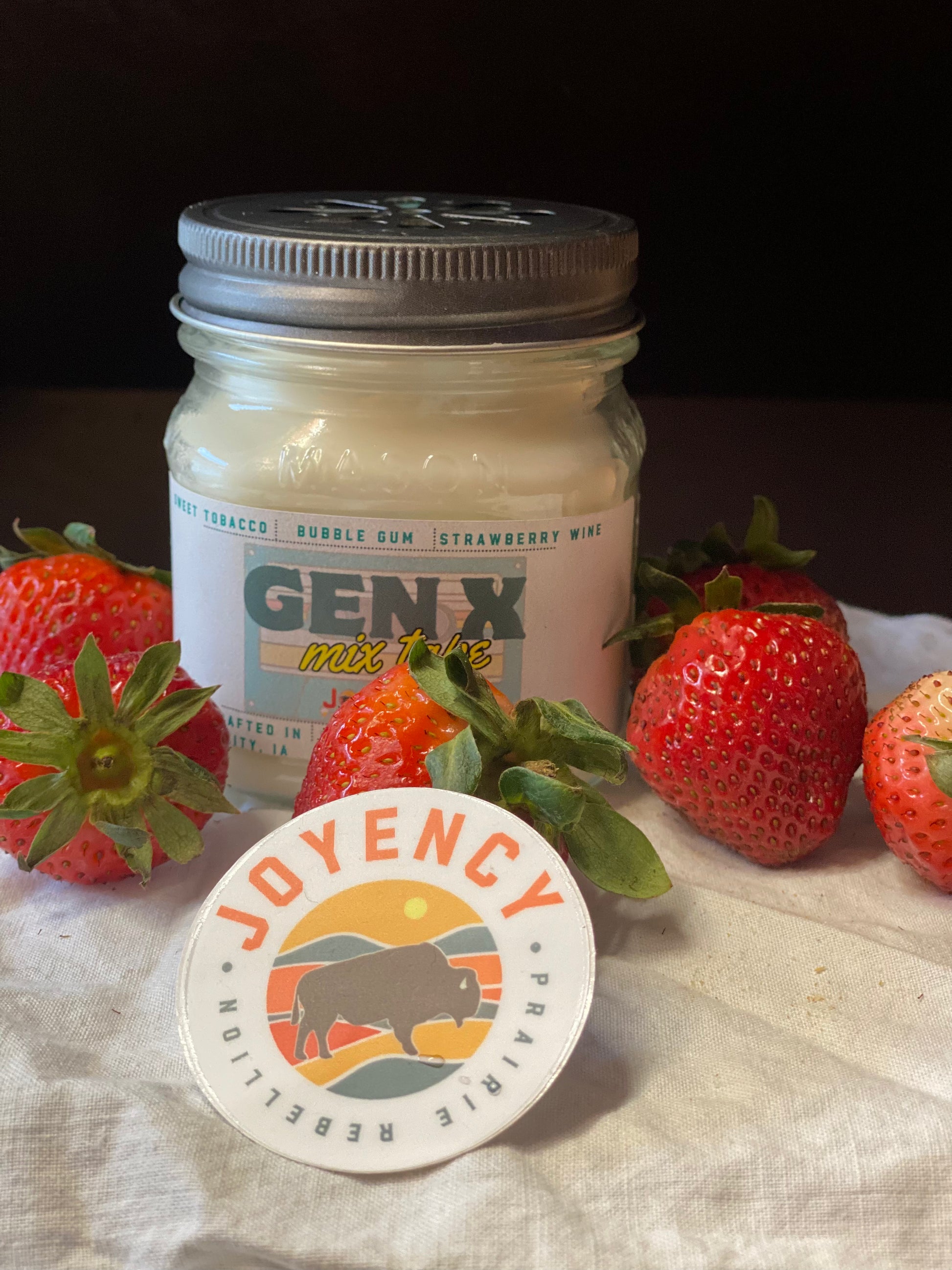 Jar of 'GENX mix' with strawberries and a 'JOYENCY' sticker on a textured surface.